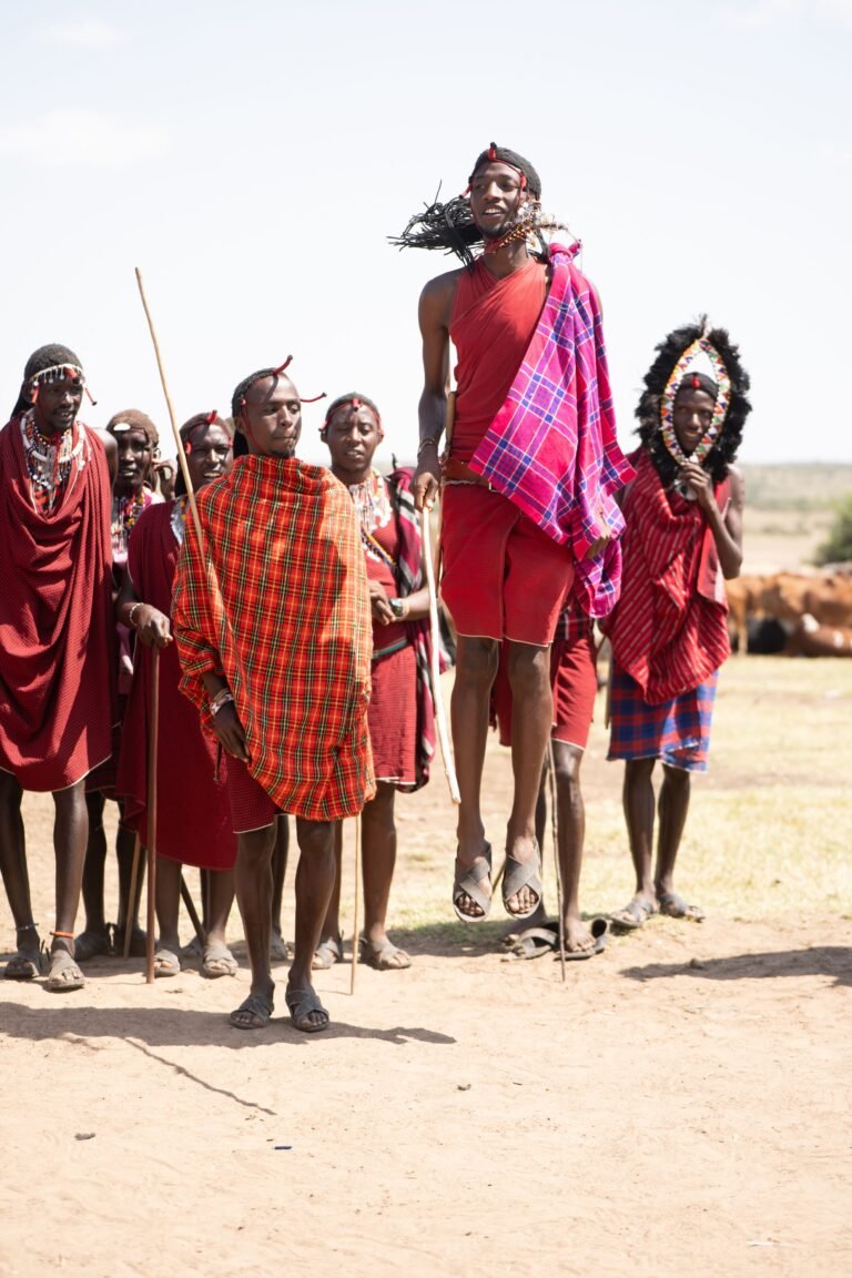 Maasai tribe members performing a traditional jumping dance in Kenya's open landscape.